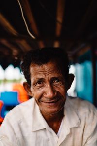 Close-up portrait of man smiling while sitting outdoors