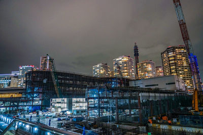 Illuminated modern buildings against sky in city at night