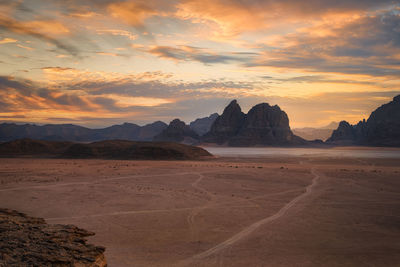 Scenic view of desert against sky during sunset