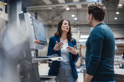 Businesswoman discussing strategy with colleague in industry