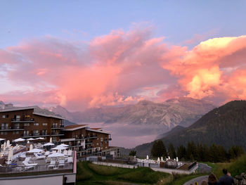 Houses and buildings against sky during sunset