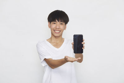 Portrait of smiling man standing against white background