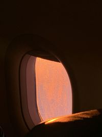 Low angle view of illuminated lamp against orange sky