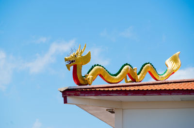 Low angle view of chinese dragon against blue sky