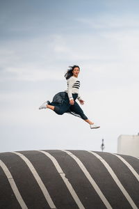 Man jumping in mid-air against sky