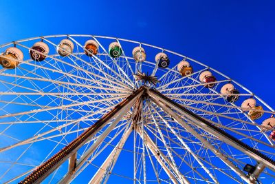 Low angle view of ferris wheel against blue sky