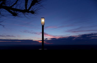 Illuminated lamp post against sky during sunset