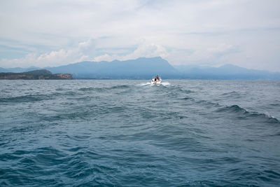 Scenic view of sea against sky with a speedboat at lake garda italy