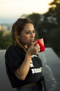 Smiling young woman drinking coffee