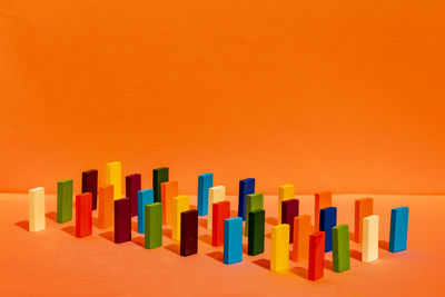 Close-up of multi colored pencils against orange background