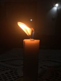 Close-up of lit candle in dark