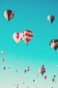 Low angle view of hot air balloons against clear blue sky