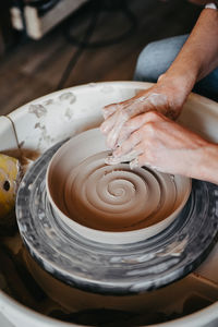 Decorating wet clay on potters wheel with a wine groove