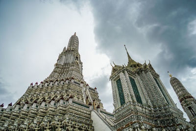 Low angle view of old ruins against cloudy sky