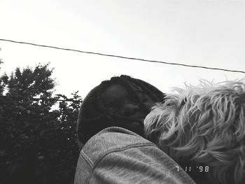 Low angle view of man and woman against sky