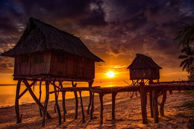 Built structure on beach against dramatic sky