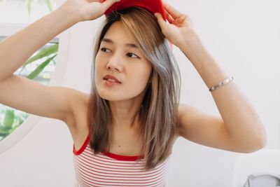 Portrait of young woman looking away against white background