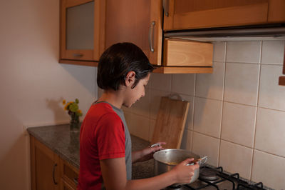 Side view of boy having food at home