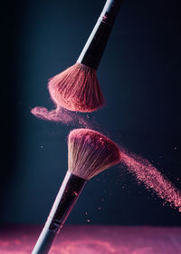 Low angle view of paintbrushes against black background