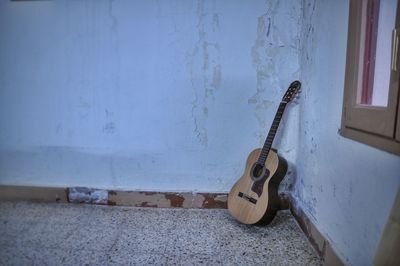 Guitar leaning on wall at home