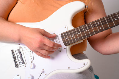 Midsection of man playing guitar