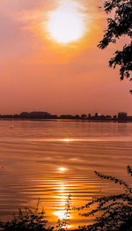 Scenic view of lake against orange sky