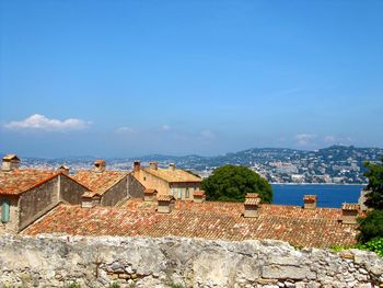 Town by sea against blue sky