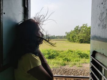 Woman standing by door in train