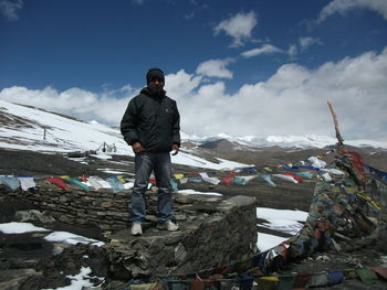 Portrait of man standing on rock during winter