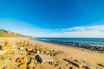 Scenic view of beach against blue sky