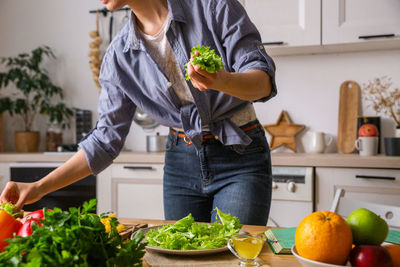 Young and beautiful housewife woman cooking in a white kitchen