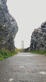 Road amidst rocks against clear sky