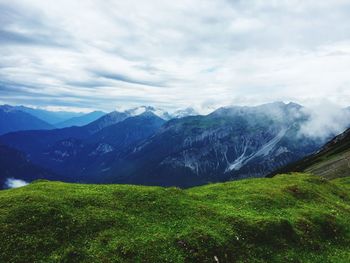 Scenic view of mountains against cloudy sky