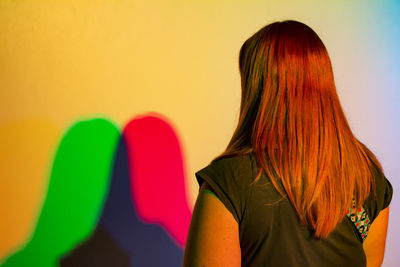 Colorful dual shadows of woman on wall