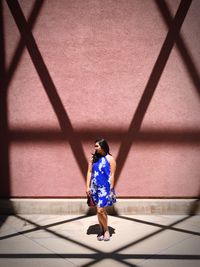 Rear view of woman standing against wall