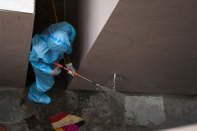 High angle view of worker spraying chemical on walls
