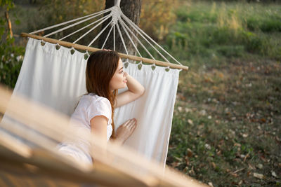 Woman sitting on hammock