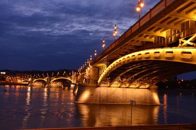 Bridge over river against cloudy sky