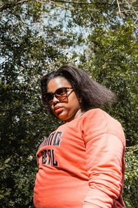 Teenage girl in sunglasses standing outdoors
