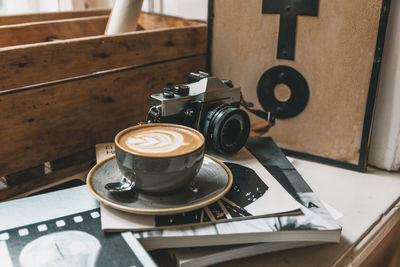 Cup of coffee with latte art on shelf in vintage photo studio