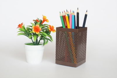 Close-up of multi colored pencils on table against white background