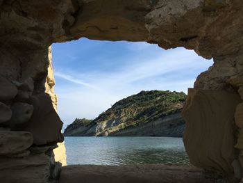 Rock formations by sea against sky