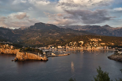 Aerial view of buildings by sea against sky