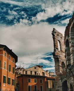 Low angle view of buildings against cloudy sky