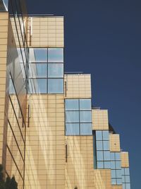 Low angle view of modern building against clear blue sky