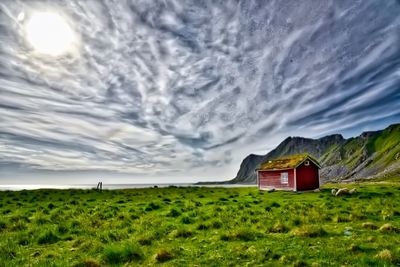 Scenic view of grassy field against cloudy sky