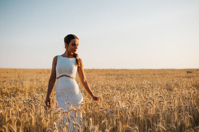 Young woman standing in wheat field