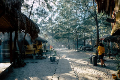 Woman standing outdoors by stilt house