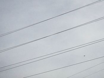 Low angle view of power lines against sky