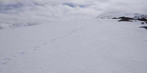 Snow covered land against sky